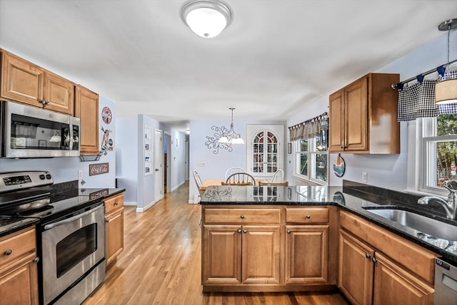 kitchen featuring pendant lighting, a wealth of natural light, appliances with stainless steel finishes, and sink