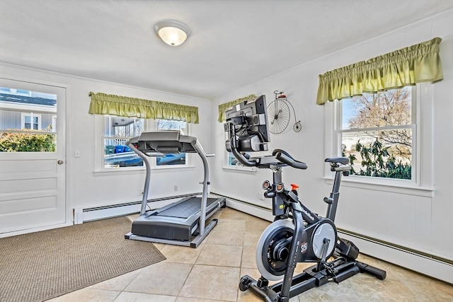 workout room with a baseboard heating unit, plenty of natural light, and light tile patterned flooring