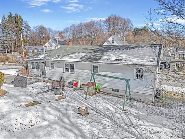 snow covered back of property with an outdoor fire pit