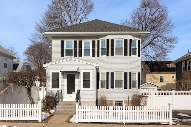 view of front of house featuring a fenced front yard and roof with shingles