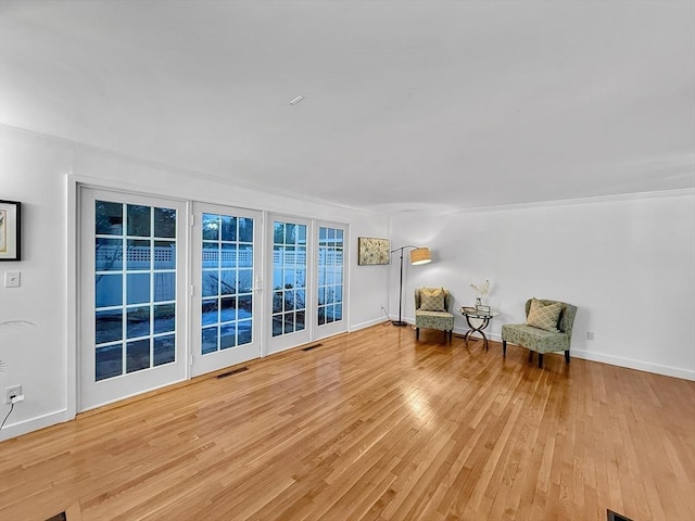 unfurnished room with visible vents, baseboards, and hardwood / wood-style flooring