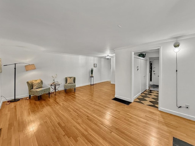 unfurnished room featuring light wood-style flooring, baseboards, and crown molding