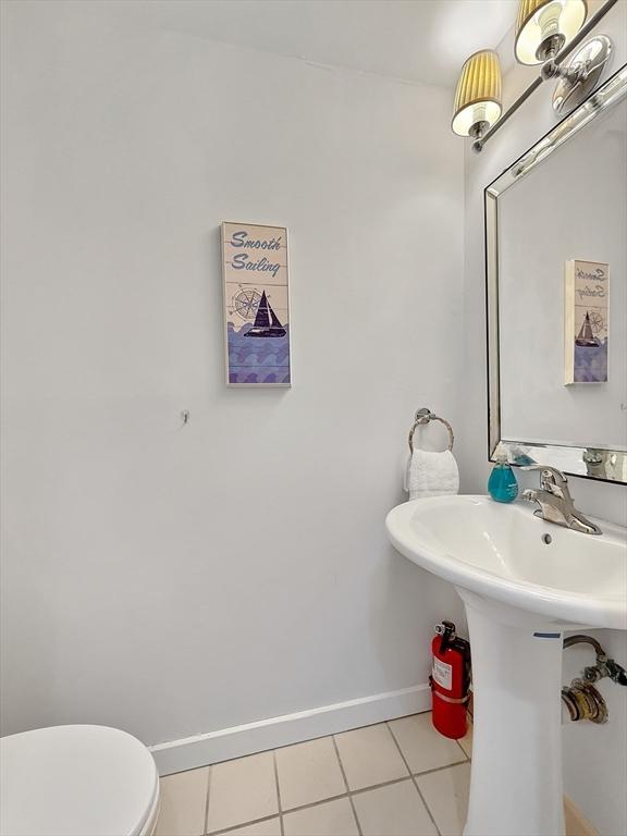 bathroom with toilet, tile patterned flooring, and baseboards