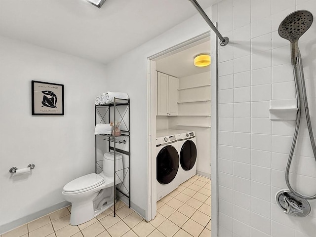 washroom featuring washing machine and dryer, light tile patterned flooring, cabinet space, and baseboards