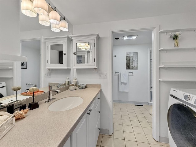 bathroom with baseboards, washer / clothes dryer, vanity, and tile patterned floors