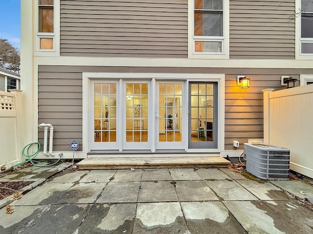 doorway to property featuring a patio area, fence, and central air condition unit