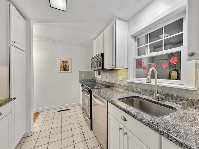 kitchen featuring white cabinets, backsplash, stainless steel appliances, and a sink