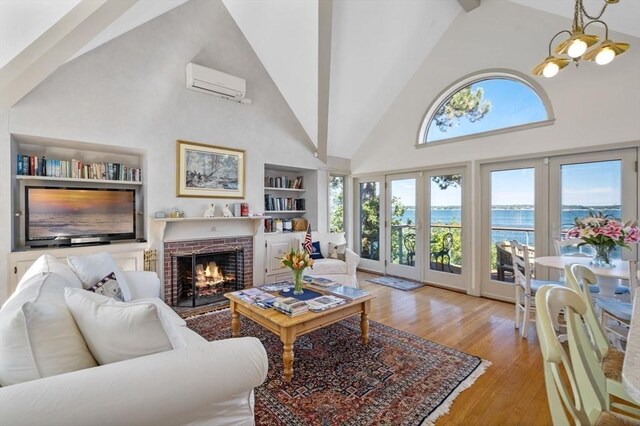 3 Anchorage Ln, Marblehead, MA 01945 - living area with high vaulted ceiling, a wall mounted AC, built in features, wood finished floors, and a fireplace