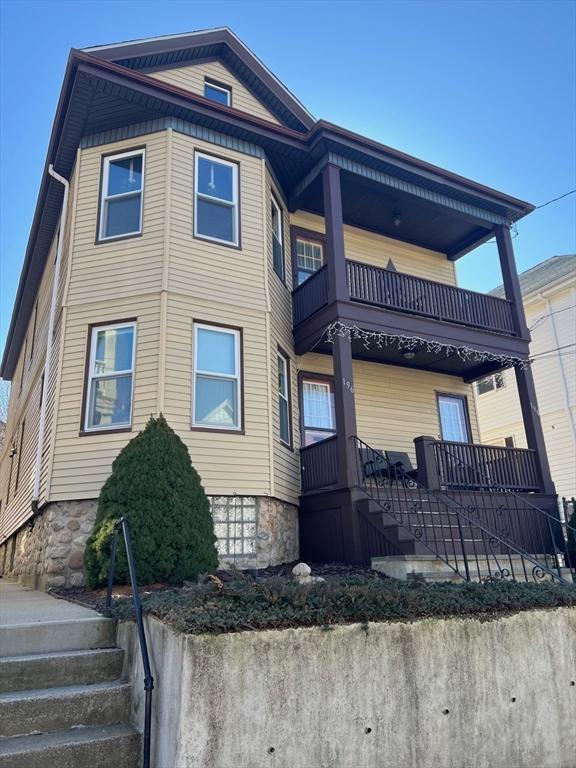 view of front of home featuring a balcony and stairway