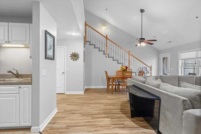 216 Reservoir St Unit 304, Holden, MA 01520 - living room with baseboards, stairs, light wood-style flooring, and a ceiling fan
