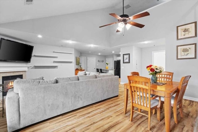 216 Reservoir St Unit 304, Holden, MA 01520 - dining space with baseboards, light wood-style flooring, a glass covered fireplace, and ceiling fan
