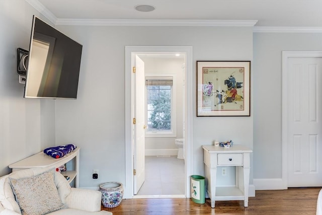 interior space featuring crown molding, baseboards, and wood finished floors