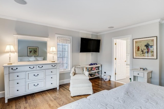 bedroom featuring connected bathroom, baseboards, wood finished floors, and crown molding