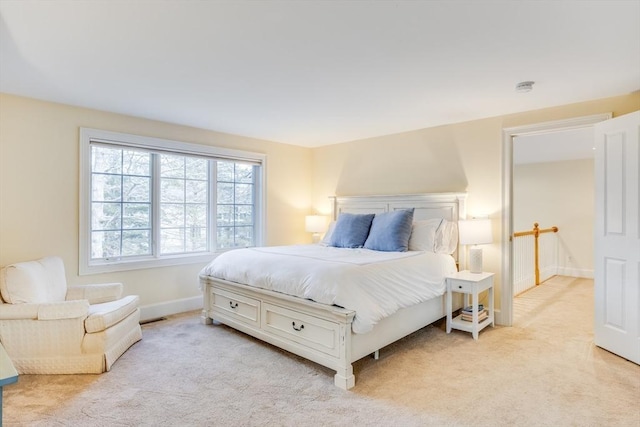 bedroom featuring light colored carpet and baseboards