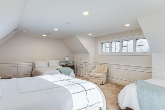 bedroom with wainscoting, recessed lighting, light colored carpet, and lofted ceiling