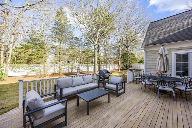 wooden deck with an outdoor hangout area, outdoor dining area, and a fenced backyard