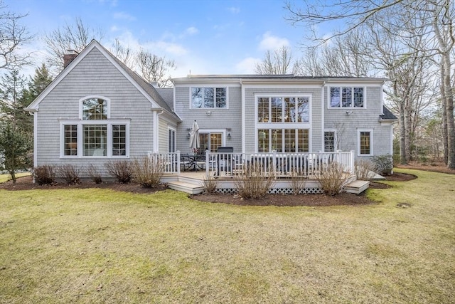 back of house featuring a wooden deck, a lawn, and a chimney