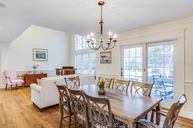 dining room featuring an inviting chandelier, light wood-style flooring, and crown molding