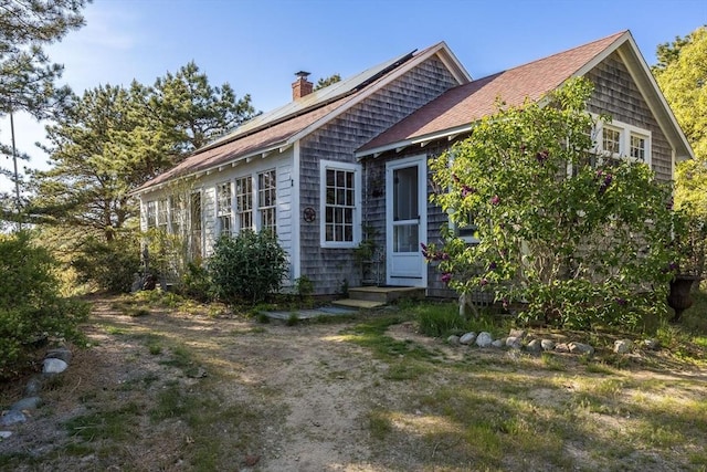 50 Higgins Ln, Wellfleet, MA 02667 - view of front of property featuring a chimney, solar panels, and roof with shingles