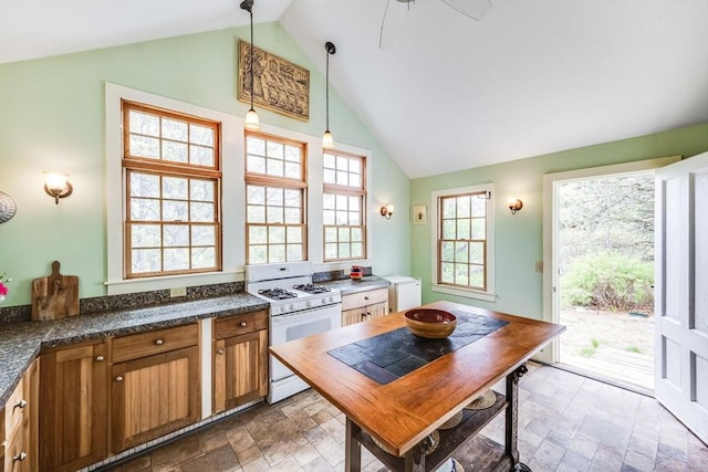 50 Higgins Ln, Wellfleet, MA 02667 - kitchen with white range with gas cooktop, brown cabinets, stone finish floors, hanging light fixtures, and high vaulted ceiling