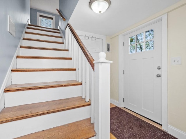 foyer entrance featuring baseboards and stairs