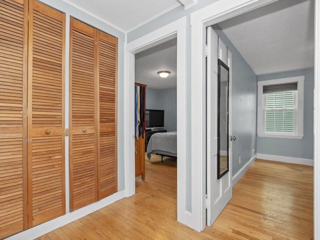 hallway featuring light wood-style floors and baseboards