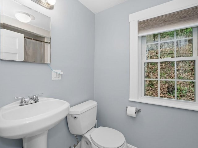 bathroom with a sink, baseboards, and toilet
