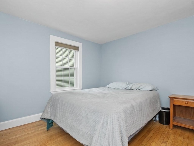 bedroom with baseboards and hardwood / wood-style flooring