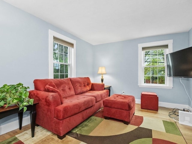 living room with a healthy amount of sunlight, baseboards, and wood finished floors