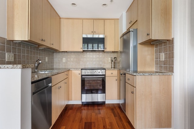 kitchen with stainless steel appliances, light stone counters, dark hardwood / wood-style flooring, and light brown cabinetry