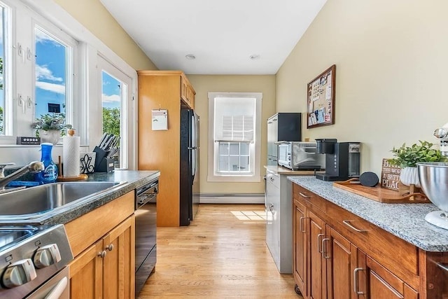 129 Vernon St Unit B, Norwood, MA 02062 - kitchen featuring a baseboard radiator, black appliances, light wood-style floors, brown cabinets, and a sink