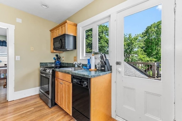129 Vernon St Unit B, Norwood, MA 02062 - kitchen featuring black appliances, a sink, dark countertops, baseboards, and light wood-style floors