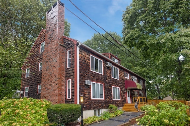 view of front of property featuring an AC wall unit