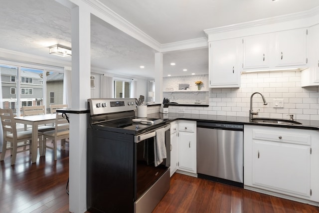 kitchen with appliances with stainless steel finishes, plenty of natural light, sink, and white cabinets