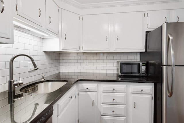 kitchen with appliances with stainless steel finishes, sink, tasteful backsplash, and white cabinetry