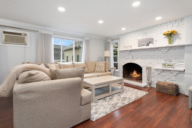 living room featuring a brick fireplace, dark hardwood / wood-style floors, a wall mounted AC, and ornamental molding