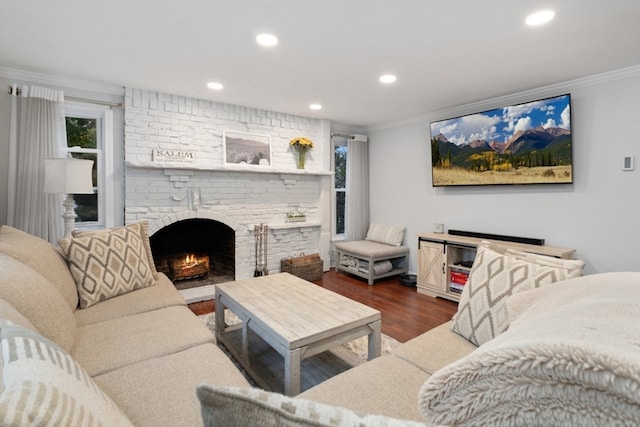 living room with a brick fireplace, crown molding, and dark hardwood / wood-style floors