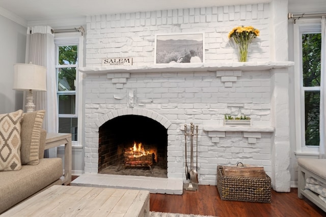 room details with a brick fireplace, hardwood / wood-style flooring, and ornamental molding