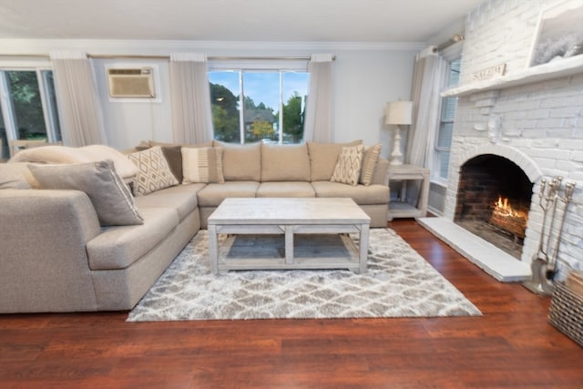 living room with a brick fireplace, crown molding, a wall mounted air conditioner, and dark hardwood / wood-style floors