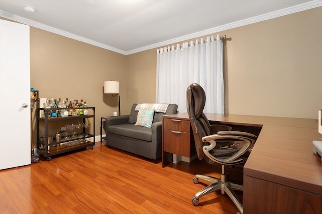 home office with light hardwood / wood-style flooring and crown molding