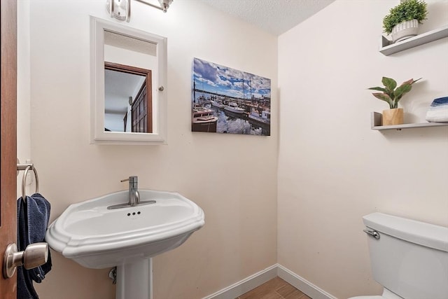 525 Tumbling Hawk Unit 525, Acton, MA 01720 - bathroom with toilet, baseboards, wood finished floors, and a sink