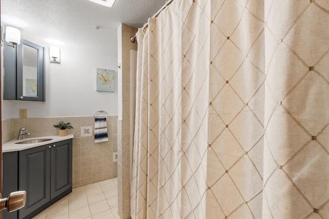 525 Tumbling Hawk Unit 525, Acton, MA 01720 - bathroom featuring tile walls, vanity, a textured ceiling, a wainscoted wall, and a shower with shower curtain