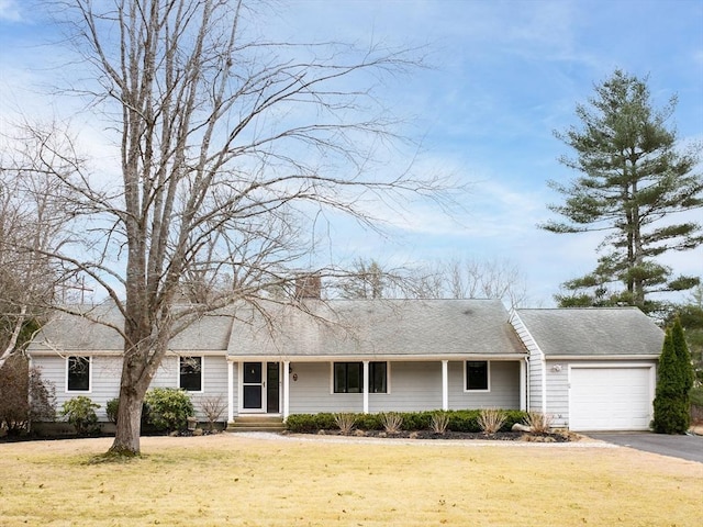 ranch-style home featuring a front lawn, entry steps, aphalt driveway, and an attached garage