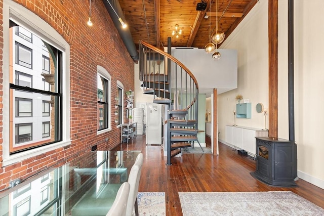 stairs with wooden ceiling, baseboards, wood-type flooring, and brick wall