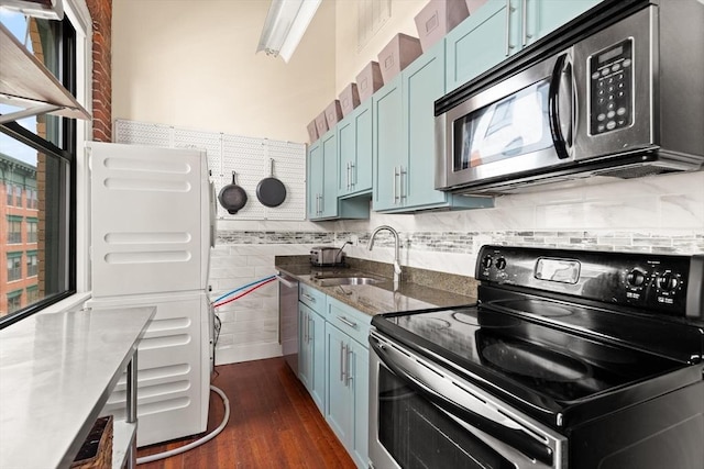 kitchen with dark wood-style flooring, electric range, stainless steel microwave, a sink, and blue cabinetry