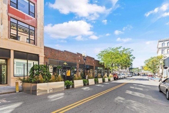 view of road featuring sidewalks, street lighting, and curbs