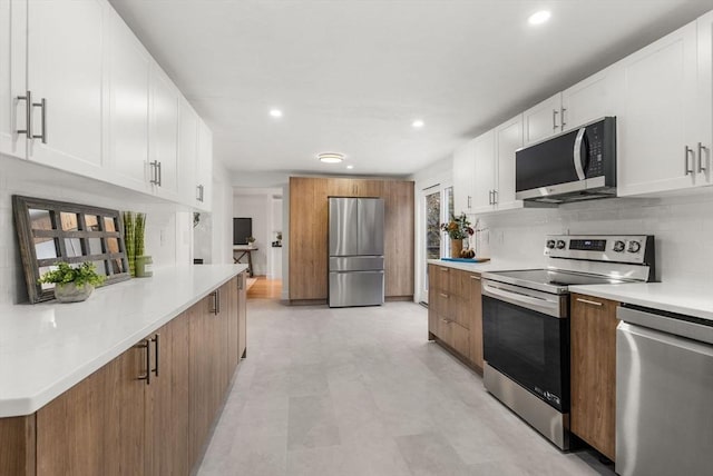 kitchen with white cabinetry, tasteful backsplash, appliances with stainless steel finishes, and light countertops