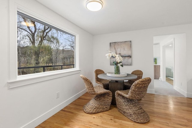 dining space with baseboards and wood finished floors