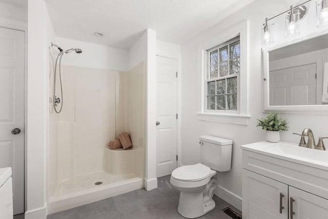 bathroom featuring a shower stall, toilet, and vanity