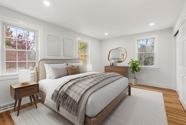 bedroom with light wood-style floors, baseboards, a closet, and recessed lighting